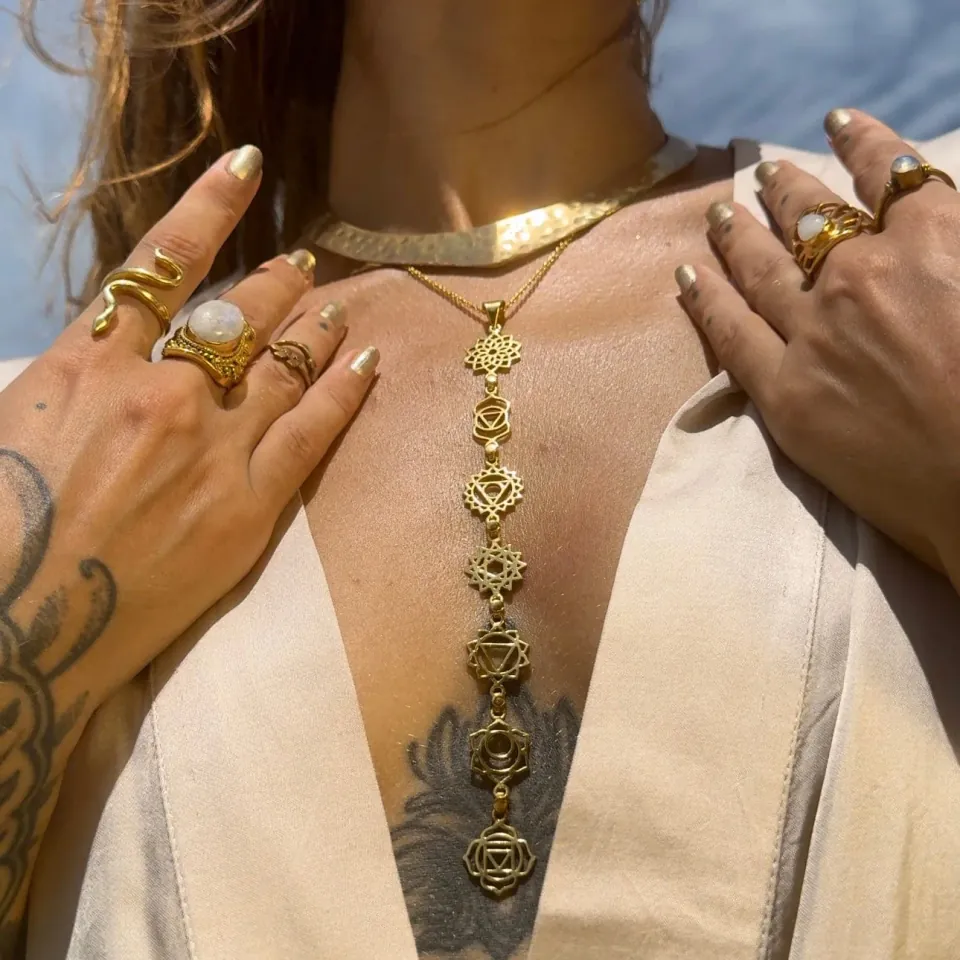 Woman wearing a gold seven-chakra necklace by Daya Jewelry